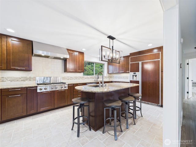 11242 Fremont Ave N Unit B, Seattle, WA 98133 - kitchen with wall chimney exhaust hood, paneled fridge, decorative backsplash, light stone countertops, and a kitchen breakfast bar