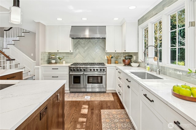 8150 Evergreen Ln, Mercer Island, WA 98040 - kitchen featuring range with two ovens, wall chimney exhaust hood, a sink, dark wood finished floors, and white cabinets