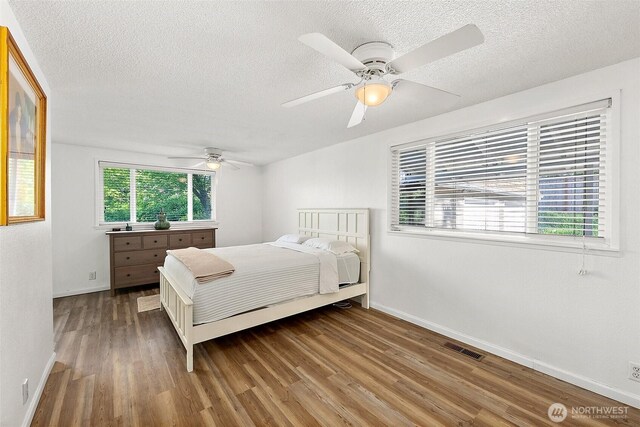 1812 5th St SE, Puyallup, WA 98372 - bedroom featuring a textured ceiling, wood finished floors, baseboards, and ceiling fan