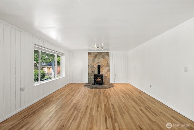 1812 5th St SE, Puyallup, WA 98372 - unfurnished living room with a wood stove, light wood-style flooring, crown molding, and baseboards