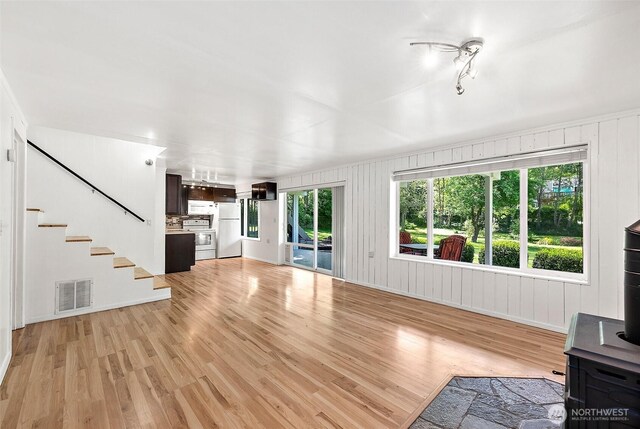 1812 5th St SE, Puyallup, WA 98372 - unfurnished living room featuring light wood finished floors, stairway, and baseboards