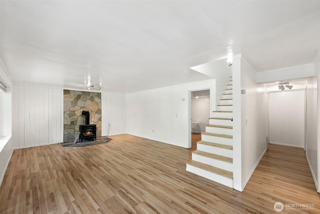 1812 5th St SE, Puyallup, WA 98372 - unfurnished living room with stairway, light wood-style flooring, a wood stove, crown molding, and baseboards