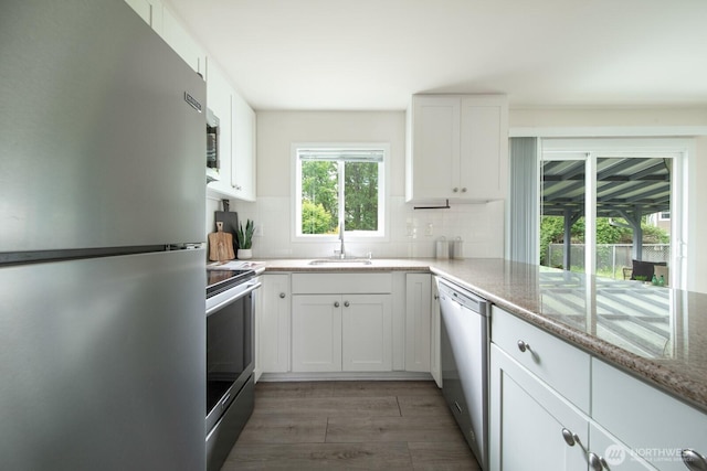 11519 SE 169th St, Renton, WA 98055 - kitchen featuring stainless steel appliances, tasteful backsplash, light wood-style flooring, and white cabinets