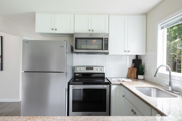 11519 SE 169th St, Renton, WA 98055 - kitchen with stainless steel appliances, light stone countertops, backsplash, and white cabinets