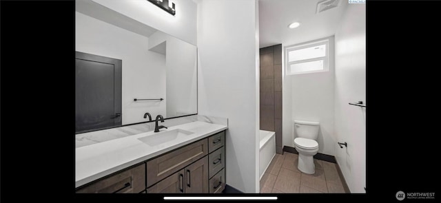 3312 Bing St, West Richland, WA 99353 - bathroom with toilet, vanity, a tub to relax in, tile patterned flooring, and baseboards
