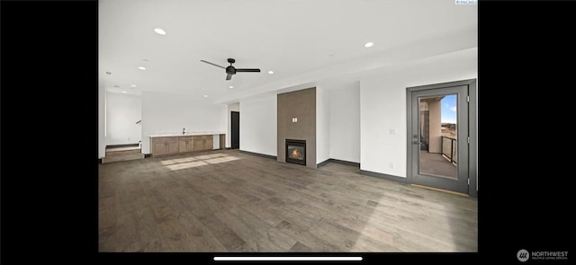 3312 Bing St, West Richland, WA 99353 - unfurnished living room featuring wood finished floors, a ceiling fan, a glass covered fireplace, recessed lighting, and baseboards
