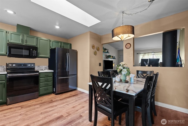 dining area with a skylight, baseboards, light wood-style flooring, and recessed lighting