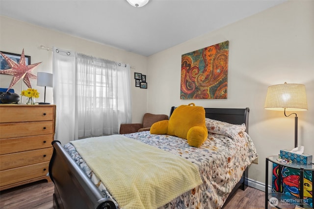 bedroom with wood finished floors and baseboards