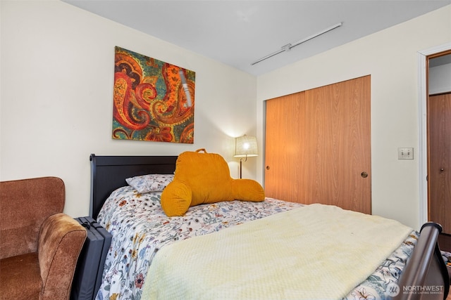 bedroom with a closet and track lighting