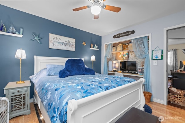 bedroom featuring wood finished floors, baseboards, and a ceiling fan