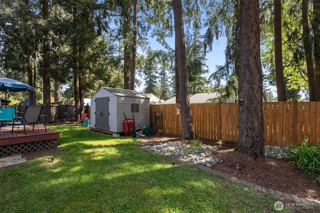 view of yard with a shed, a wooden deck, and an outbuilding