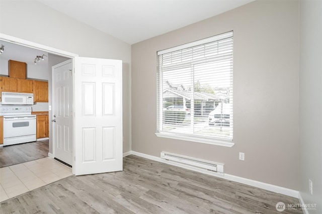 5400 Harbour Pointe Blvd Unit E102, Mukilteo, WA 98275 - unfurnished dining area featuring a baseboard radiator, light wood-style floors, and baseboards