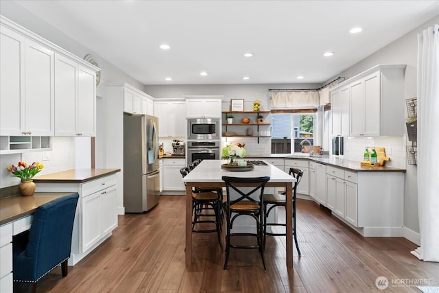 kitchen featuring stainless steel appliances, open shelves, backsplash, white cabinets, and recessed lighting