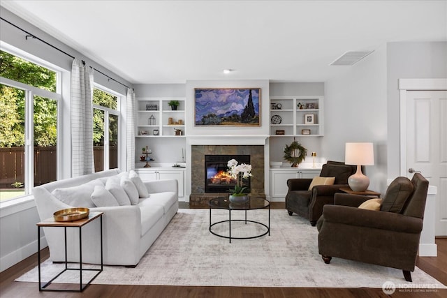 living area with wood finished floors, a fireplace, and baseboards