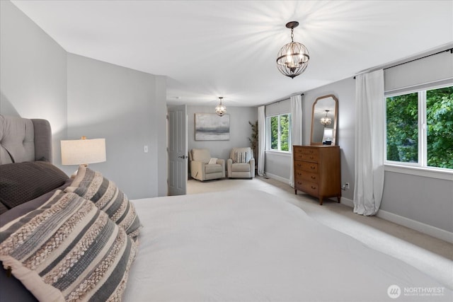 bedroom with a chandelier, carpet floors, and baseboards