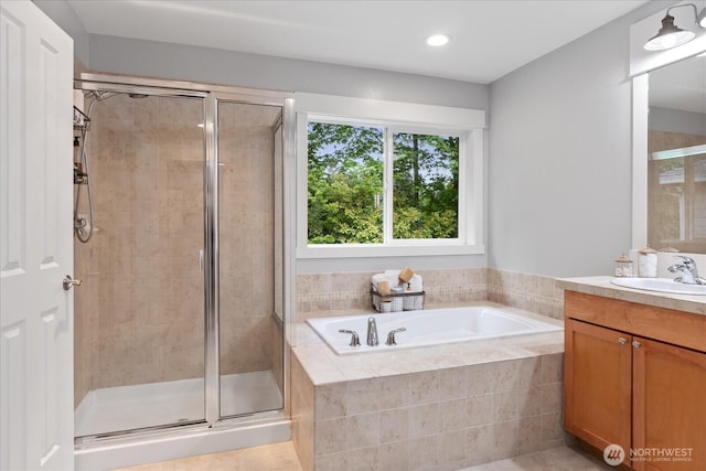 bathroom featuring a shower stall, a garden tub, vanity, and recessed lighting
