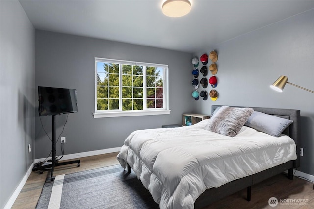 bedroom featuring wood finished floors and baseboards