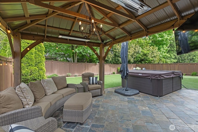 view of patio / terrace with a hot tub, a fenced backyard, an outdoor living space, and a gazebo