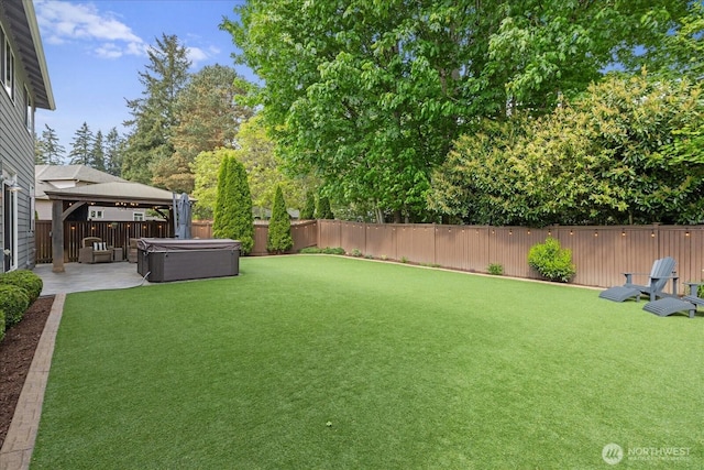 view of yard with a hot tub, a patio area, and a gazebo