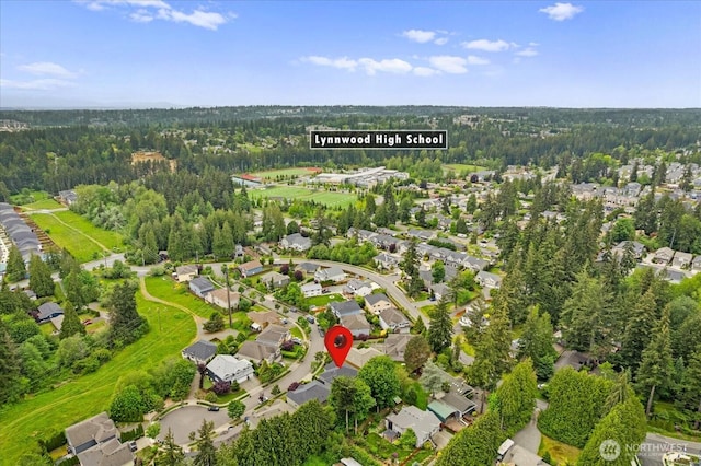 view of property location featuring nearby suburban area and a forest