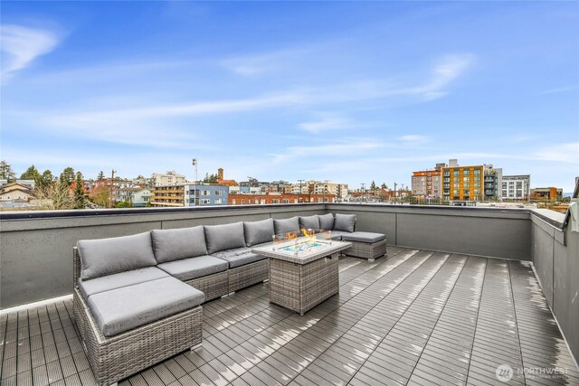 wooden deck with an outdoor living space with a fire pit and a city view