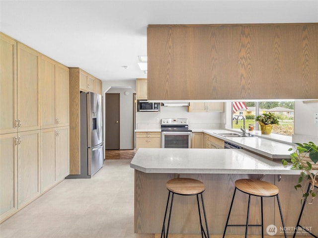 12120 A St S, Tacoma, WA 98444 - kitchen featuring stainless steel appliances, light brown cabinets, a peninsula, and light countertops