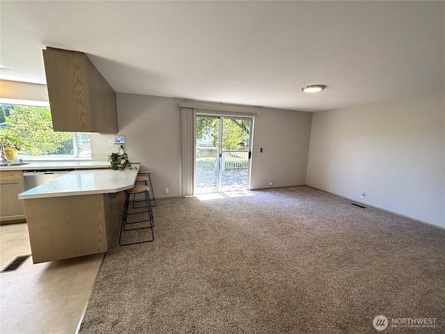12120 A St S, Tacoma, WA 98444 - kitchen with a kitchen breakfast bar, a peninsula, light colored carpet, light countertops, and stainless steel dishwasher