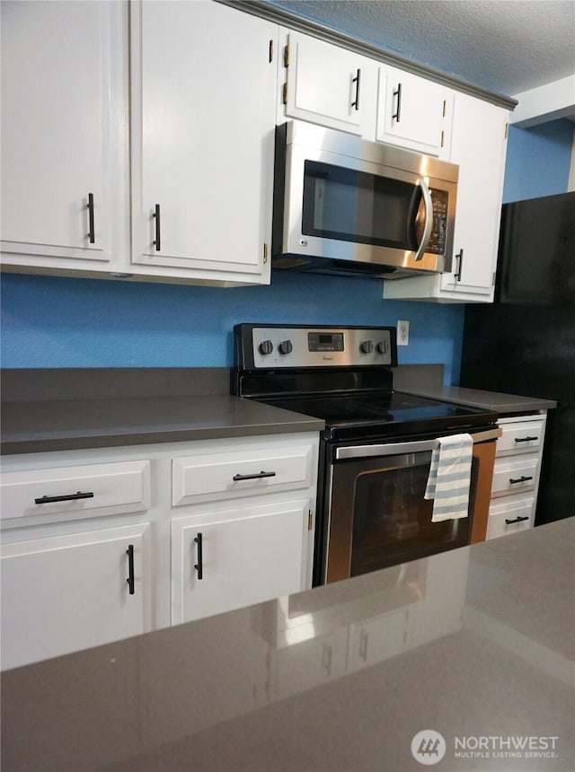 3435 Auburn Way S Unit 15, Auburn, WA 98092 - kitchen featuring stainless steel appliances, white cabinetry, and dark countertops