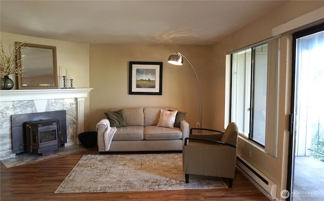 3435 Auburn Way S Unit 15, Auburn, WA 98092 - living area featuring a baseboard heating unit, wood finished floors, and a wood stove