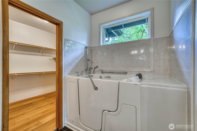 5011 81st St SW, Lakewood, WA 98499 - full bathroom with washer / clothes dryer, wood finished floors, a bath, and a walk in closet