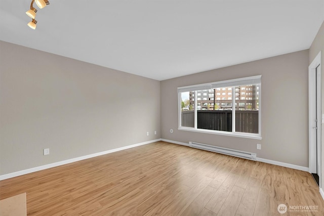 1175 Harrington Pl NE Unit 101, Renton, WA 98056 - empty room with a baseboard radiator, light wood-style flooring, and baseboards