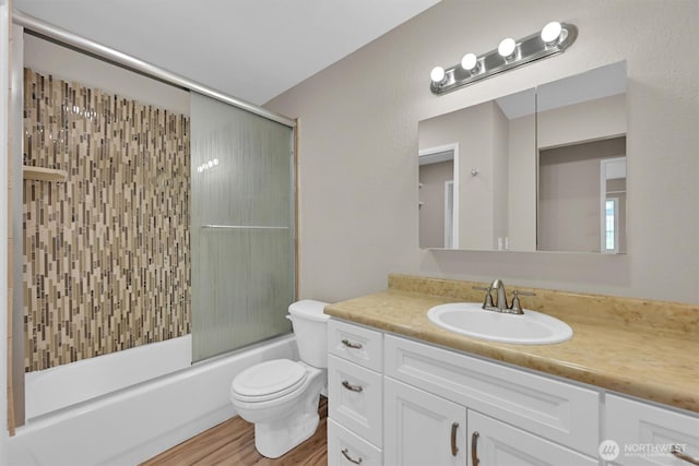 1175 Harrington Pl NE Unit 101, Renton, WA 98056 - full bath with toilet, enclosed tub / shower combo, vanity, and wood finished floors