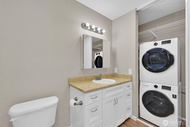 1175 Harrington Pl NE Unit 101, Renton, WA 98056 - half bath featuring stacked washing machine and dryer, toilet, and vanity