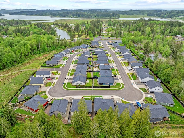 aerial view of property's location with a large body of water, nearby suburban area, and a forest