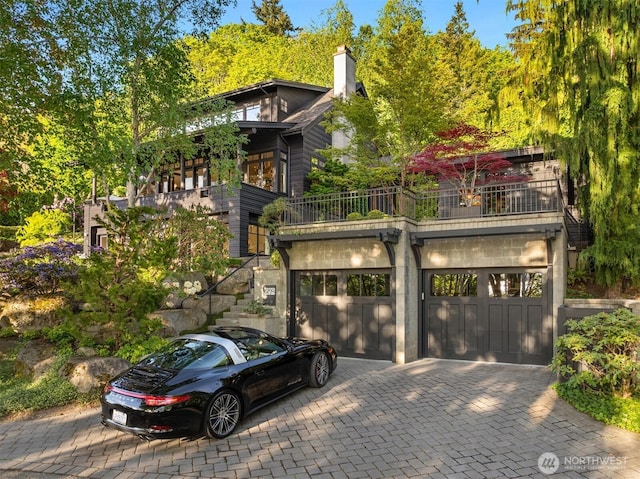 10208 47th Ave SW, Seattle, WA 98146 - view of front of home featuring a balcony, decorative driveway, a garage, and a chimney