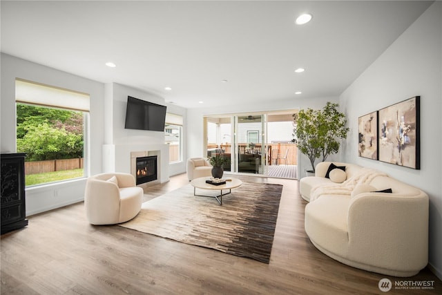 12421 Harwood Cove Ln SW, Lakewood, WA 98498 - living area featuring a glass covered fireplace, plenty of natural light, wood finished floors, and recessed lighting