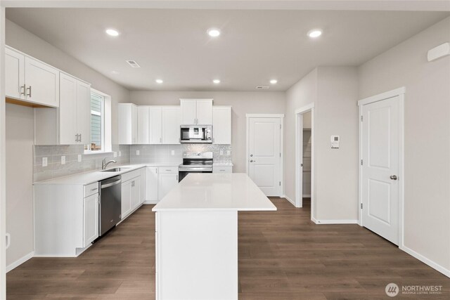 14903 202nd Avenue Ct E Unit 691, Bonney Lake, WA 98391 - kitchen featuring stainless steel appliances, a center island, tasteful backsplash, dark wood finished floors, and recessed lighting