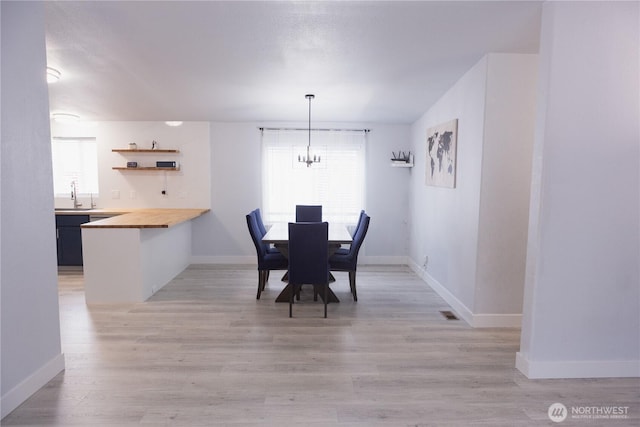 21833 127th Ave SE, Snohomish, WA 98296 - dining space with a chandelier, baseboards, and light wood finished floors
