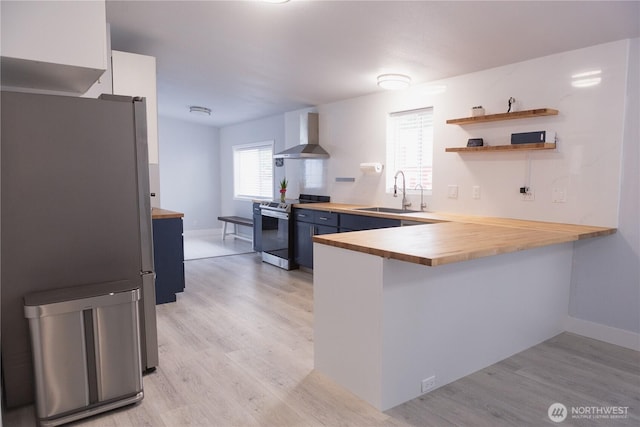 21833 127th Ave SE, Snohomish, WA 98296 - kitchen with appliances with stainless steel finishes, a sink, blue cabinetry, wall chimney range hood, and wooden counters