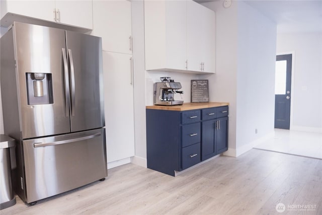 21833 127th Ave SE, Snohomish, WA 98296 - kitchen with stainless steel fridge with ice dispenser, light wood-style floors, white cabinetry, blue cabinetry, and baseboards
