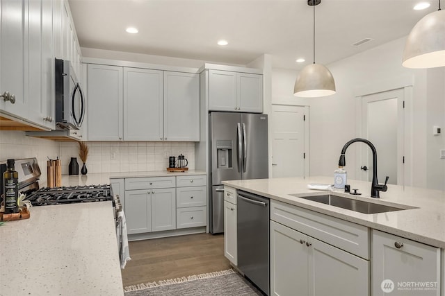 8008 222nd St SW, Edmonds, WA 98026 - kitchen with a sink, stainless steel appliances, wood finished floors, light stone countertops, and backsplash