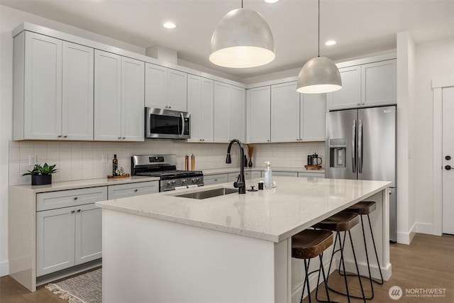 8008 222nd St SW, Edmonds, WA 98026 - kitchen with appliances with stainless steel finishes, a sink, a kitchen breakfast bar, decorative backsplash, and recessed lighting