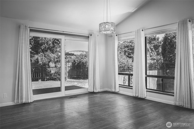 87 Swinomish Dr, La Conner, WA 98257 - unfurnished dining area featuring a chandelier, plenty of natural light, lofted ceiling, wood-type flooring, and baseboards