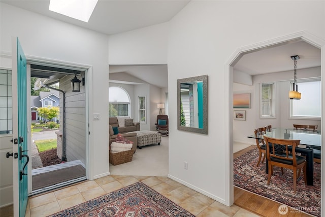 805 E Pacificview Dr, Bellingham, WA 98229 - entryway with vaulted ceiling, baseboards, a skylight, and light tile patterned floors