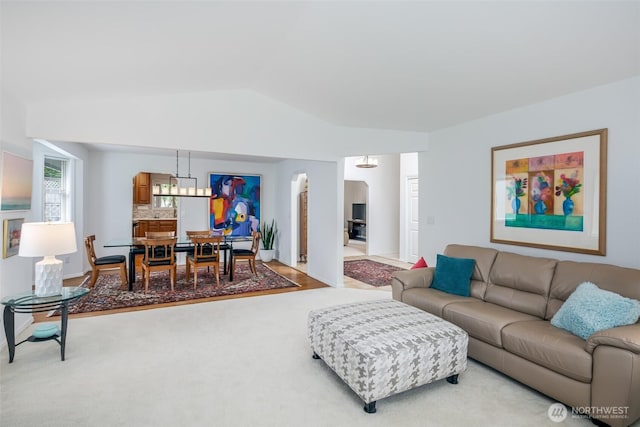 805 E Pacificview Dr, Bellingham, WA 98229 - living area featuring arched walkways, lofted ceiling, a chandelier, and light carpet