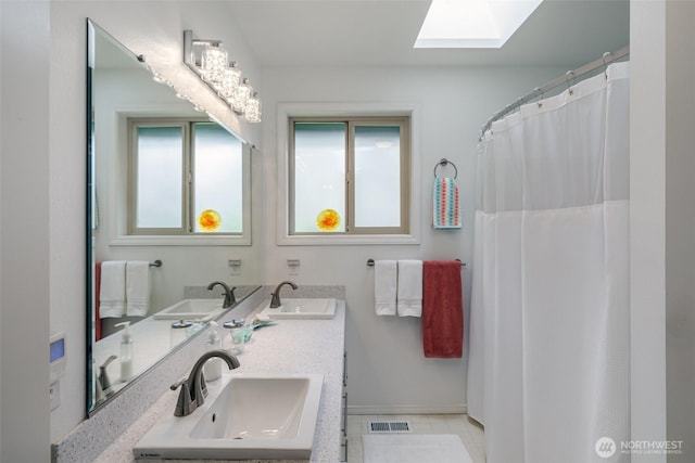 805 E Pacificview Dr, Bellingham, WA 98229 - bathroom with a skylight, double vanity, and baseboards