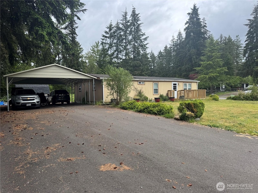 view of front of house with driveway, a carport, and a front yard
