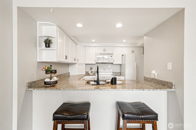 7 Lake Bellevue Dr Unit 109, Bellevue, WA 98005 - kitchen with white appliances, a peninsula, light stone counters, open shelves, and recessed lighting