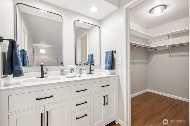 7 Lake Bellevue Dr Unit 109, Bellevue, WA 98005 - full bath featuring wood finished floors, a walk in closet, baseboards, and double vanity