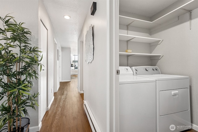 7 Lake Bellevue Dr Unit 109, Bellevue, WA 98005 - washroom with a baseboard heating unit, wood finished floors, washer and dryer, and baseboards